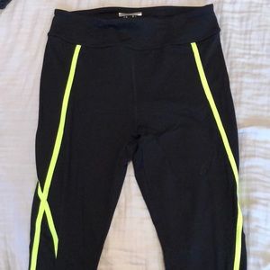 Black workout leggings with green X pattern on leg